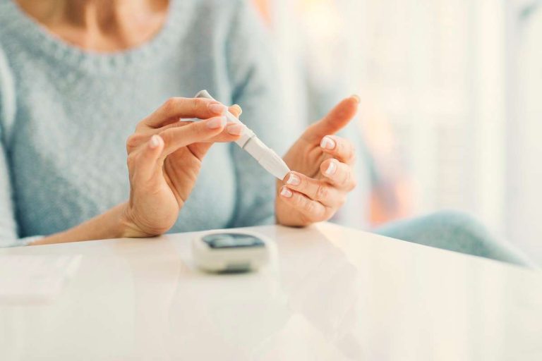 mulher medindo glicose e alertando os sintomas do diabetes