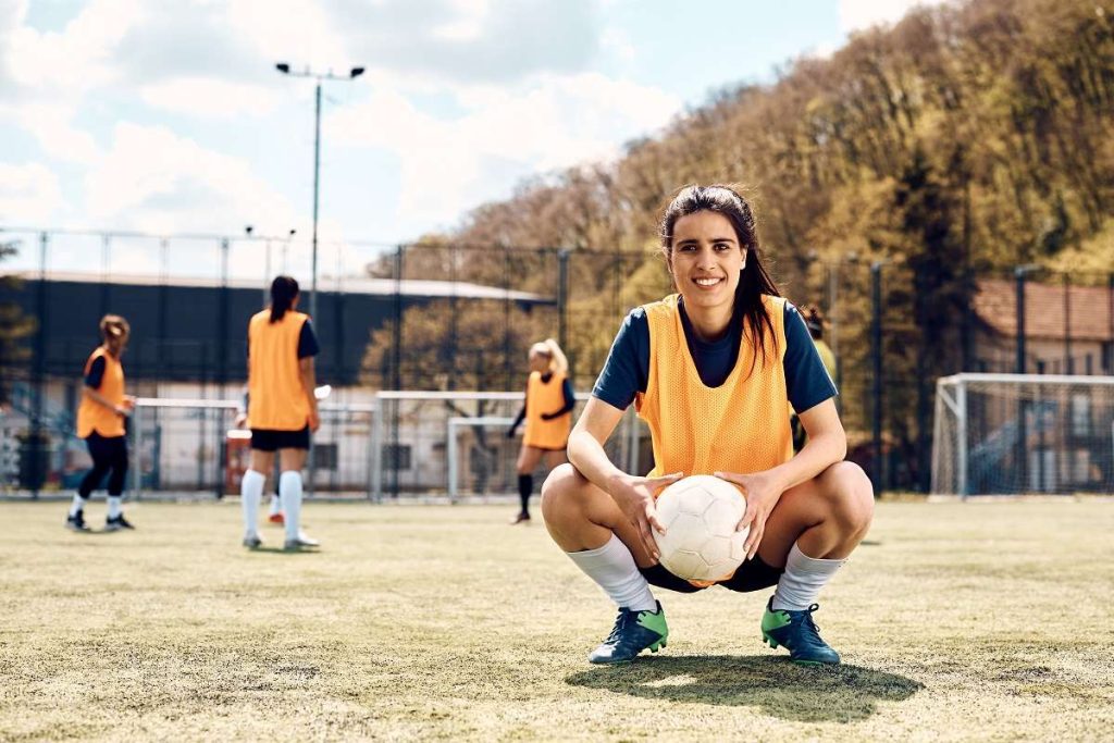 mulher praticando futebol feminino