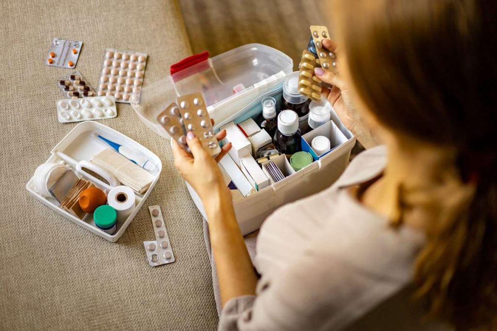 mulher confere medicamentos na farmacinha doméstica