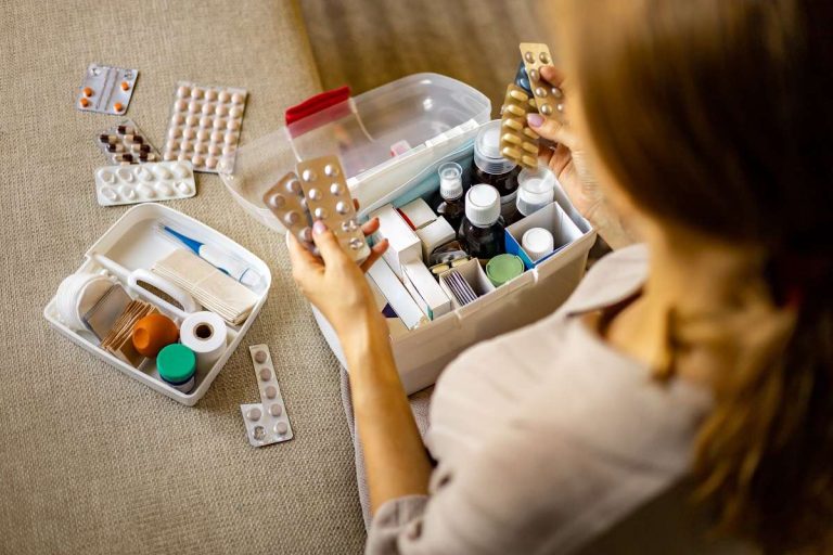 mulher confere medicamentos na farmacinha doméstica